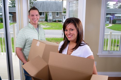 Professional movers carrying furniture during a house removal in West Kensington