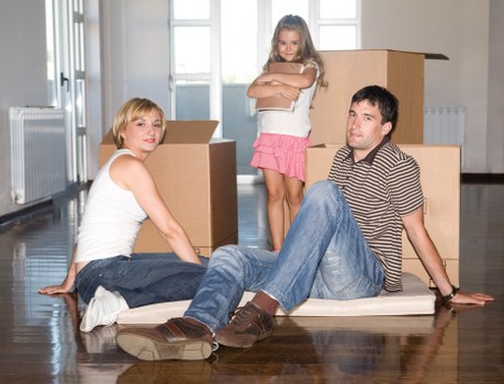 Movers carrying packed boxes and furniture in a flat move